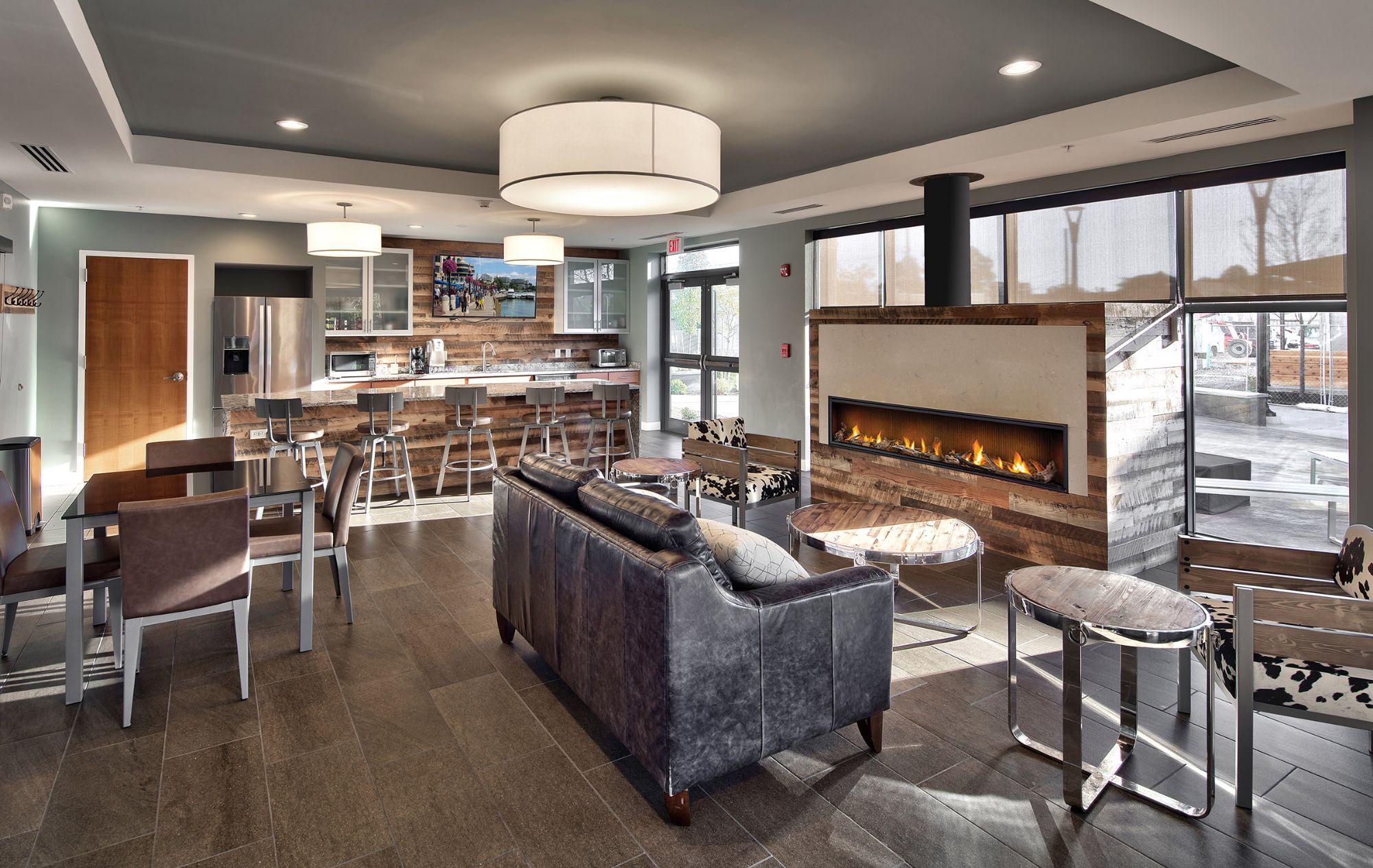 Community room with fireplace, leather sofas and kitchen bar